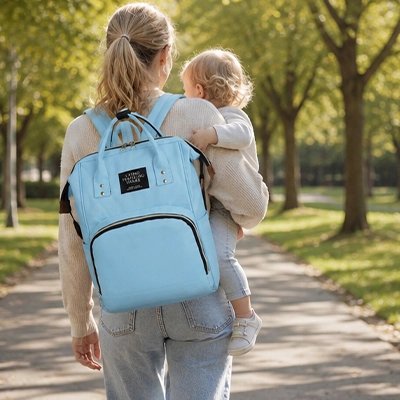 Sac a dos a langer bleu ciel porter par une maman dans la rue 